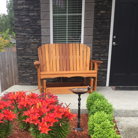 western cedar garden glider bench on a porch